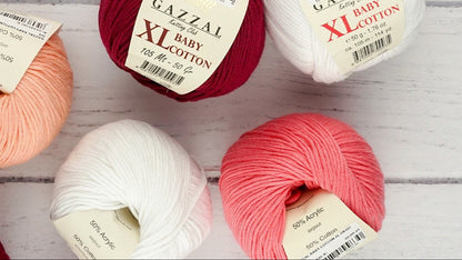 Gazzal Baby Cotton yarn balls in various colors on a wooden surface