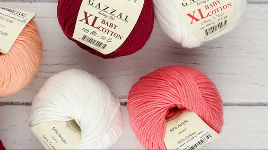 Gazzal Baby Cotton yarn balls in various colors on a wooden surface